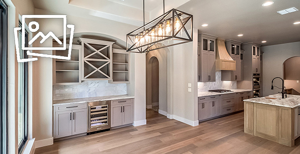 Custom wine bar with built-in cabinetry, beverage refrigerator, designer lighting, and open-concept entertaining space in a luxury custom home in Bulverde, Texas.