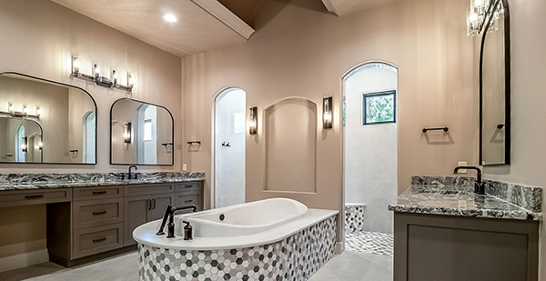 Luxury primary bathroom featuring a freestanding soaking tub, dual vanities, custom tile shower, and elegant finishes in a custom Bulverde TX home.